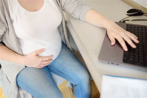 Donna incinta che studia al computer
