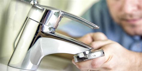 Immagine di un idraulico che ripara un rubinetto che gocciola.