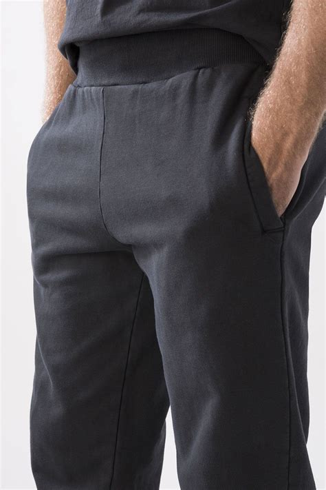 Dettaglio di un pantalone sportivo con polsino e cordino regolabile in vita