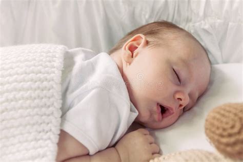 Immagine di un neonato che dorme serenamente con un ciuccio