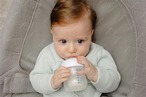 Happy baby drinking milk from bottle