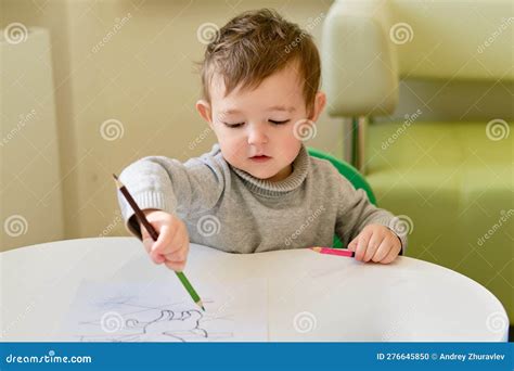 Bambino che traccia linee su un foglio di carta con una matita colorata