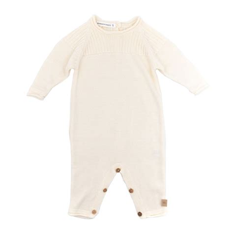 Dettaglio ravvicinato di una tutina in maglia Hermès, evidenziando la precisione del ricamo Cabriole e la morbidezza del cotone naturale utilizzato.