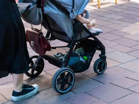 Mani di bambino che si allontanano da meccanismi del passeggino