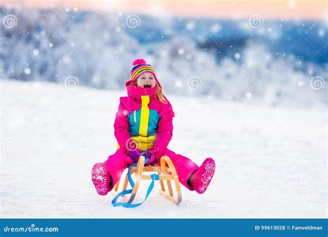 Bambino in tutina da neve che gioca sulla neve
