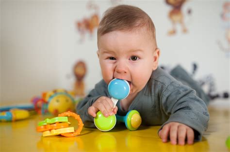 Bambino che porta oggetti alla bocca con curiosità