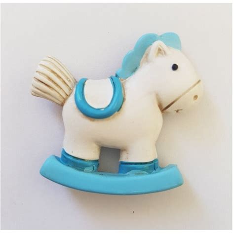 dettaglio di una calamita a forma di cavalluccio a dondolo su base azzurra