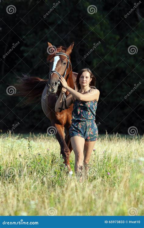 Donna a cavallo in un prato
