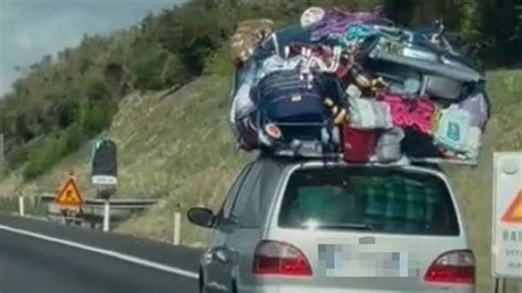 Famiglia che carica l'auto per un viaggio con molti bagagli