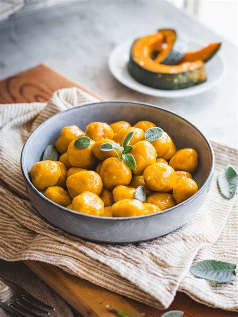 Bambino felice che gusta gnocchi di zucca tagliati a pezzetti