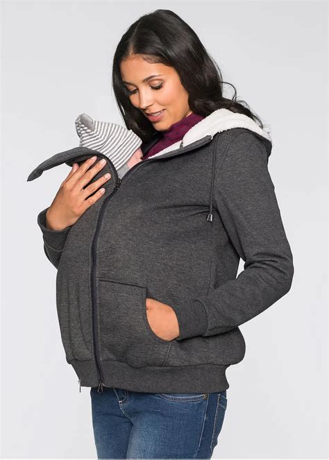 Donna che utilizza una giacca premaman multiuso con inserto per il babywearing
