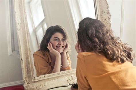 Donna che si guarda allo specchio con un sorriso