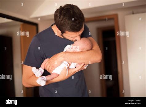 Un neonato tra le braccia del padre