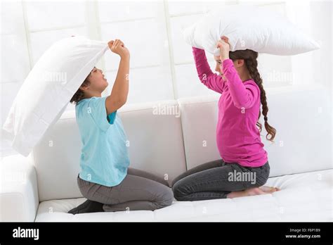Bambine che fanno la battaglia di cuscini