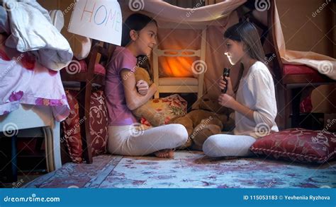 Bambine che raccontano storie con la torcia sotto il mento