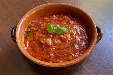 piatto fumante di pappa al pomodoro guarnito con basilico fresco