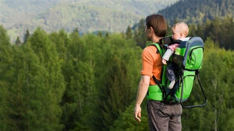 Genitore e bambino riposano durante un'escursione con zaino porta bebè