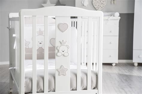 dettaglio di un lettino per neonato con tessuti decorati in color tortora