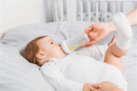 Bambino che beve dal biberon, con enfasi sulla sicurezza e la nutrizione