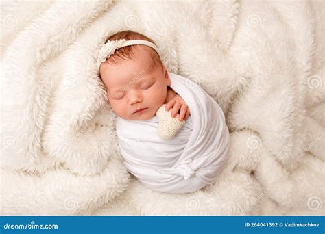 Una tenera immagine di una neonata che dorme serenamente con decorazioni delicate attorno