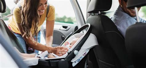 famiglia felice che prepara un viaggio in auto con un neonato