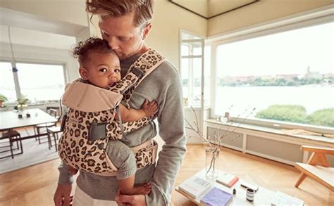 genitore che utilizza un marsupio ergonomico con il neonato in posizione corretta