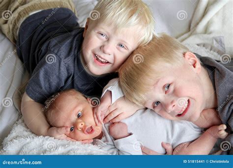 Fratelli che abbracciano il neonato