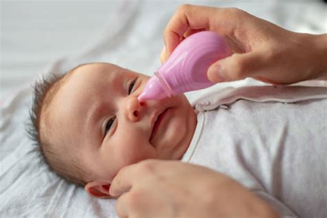 Bambino che usa aspiratore nasale