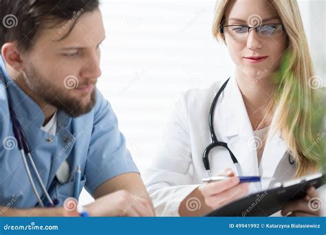 Donna incinta e medico che consultano dei referti medici