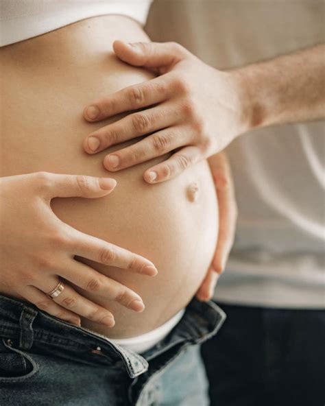 Mani di padre e madre che accarezzano la pancia della mamma