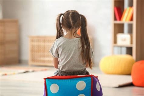 Bambina che gioca da sola in un angolo di una stanza colorata
