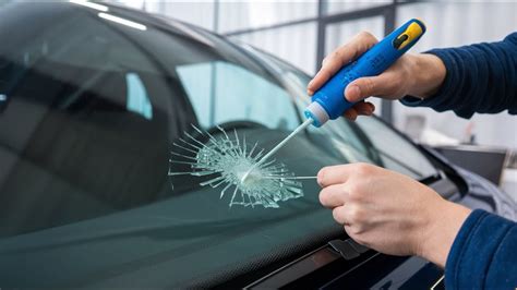 tecnico specializzato che lavora sulla riparazione di un parabrezza di un'auto in un'officina moderna
