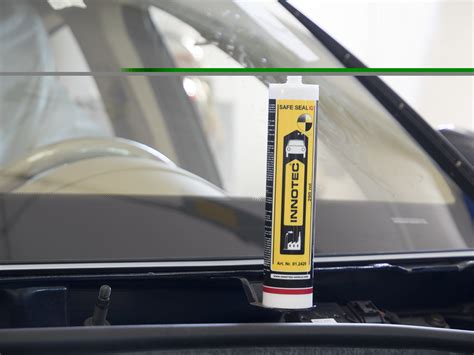 dettaglio ravvicinato della posa del sigillante per il parabrezza effettuata da un esperto