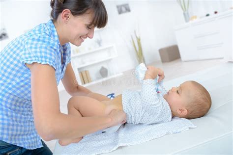 Mamma che cambia il pannolino al suo bambino