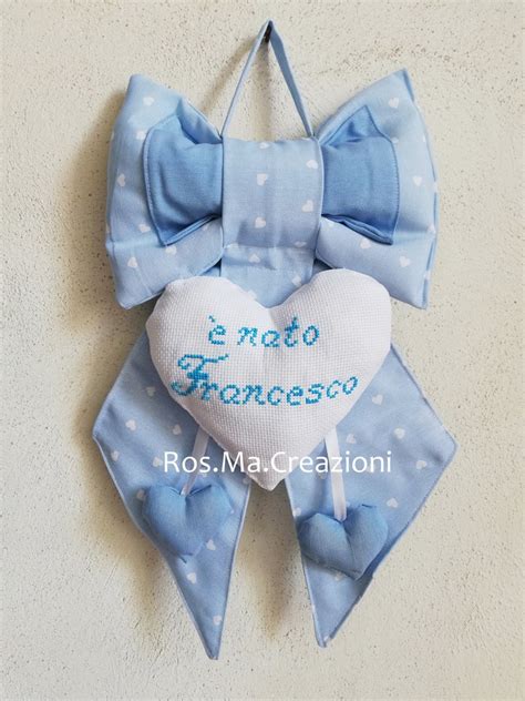 Illustrazione di un fiocco nascita ricamato con il nome Lorenzo