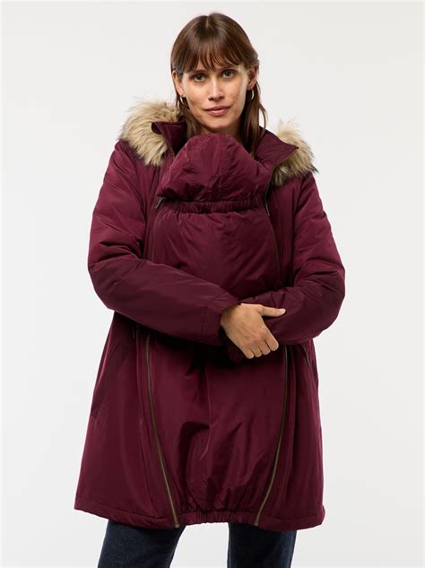 Donna con parka premaman e cappuccio, con un marsupio sotto