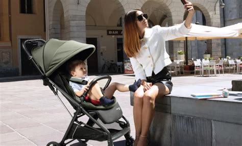 Bambino felice in un passeggino Peg Perego