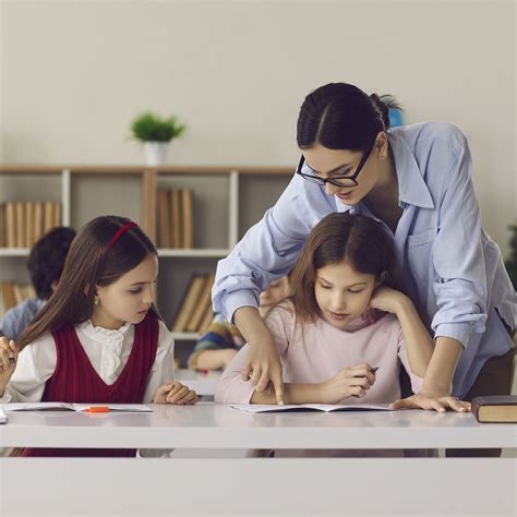 Educatore che osserva il lavoro dei bambini in aula