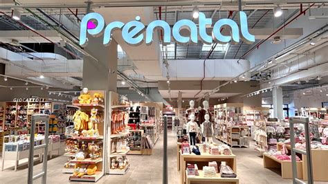 un bambino felice circondato da articoli per l'infanzia in un negozio Prénatal