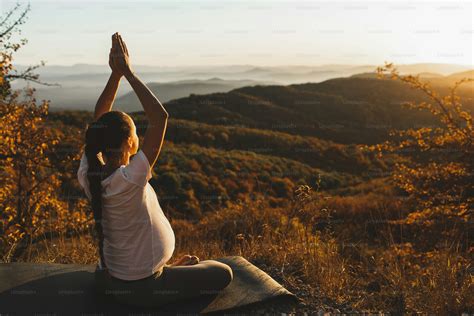 donna incinta che pratica yoga all'aperto al tramonto