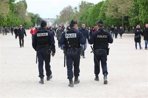 Un agente di polizia francese mentre controlla i documenti a un migrante