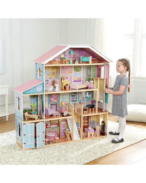 bambino che gioca con una casa delle bambole in legno