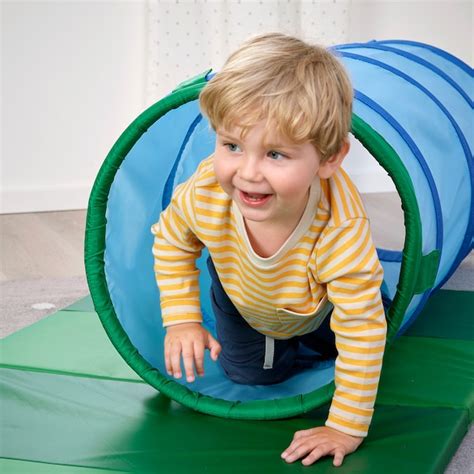 bambino che esplora un tunnel di gioco colorato