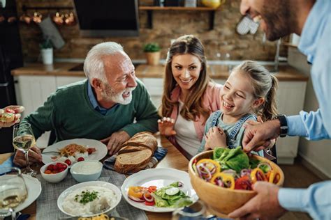 Bambino che osserva i genitori mangiare a tavola