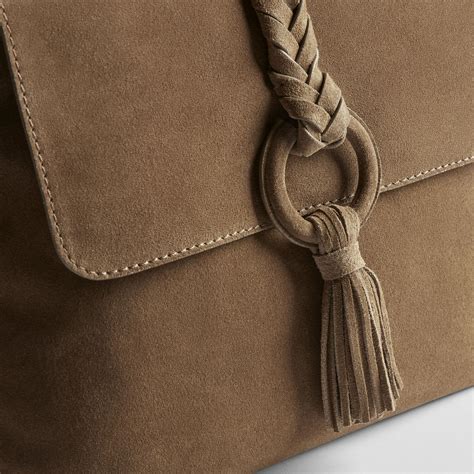Donna che pulisce una borsa scamosciata