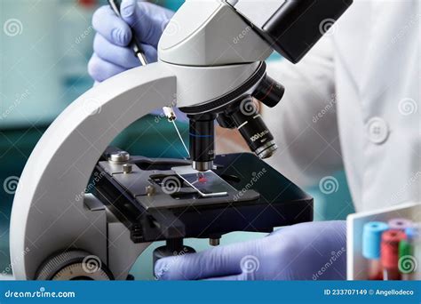 Scienziato che esamina campioni di capelli al microscopio