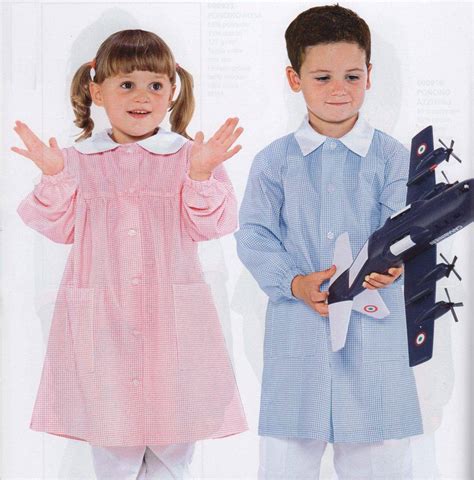 bambino che indossa un grembiule scolastico con colori e simboli sportivi