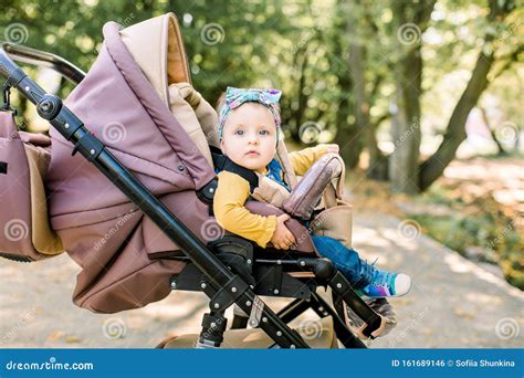 bambino in un passeggino ben attrezzato con coprigambe durante una passeggiata autunnale