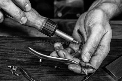 Mani di un artigiano che lavorano una scarpa