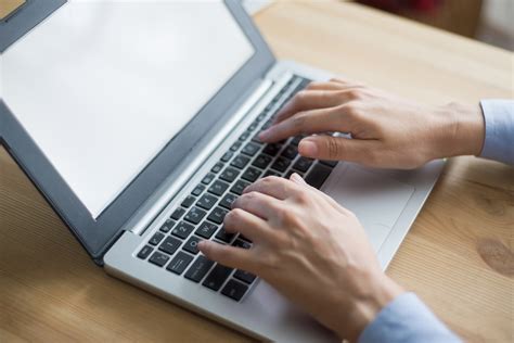 Persona che lavora al computer con documenti relativi a bandi agricoli